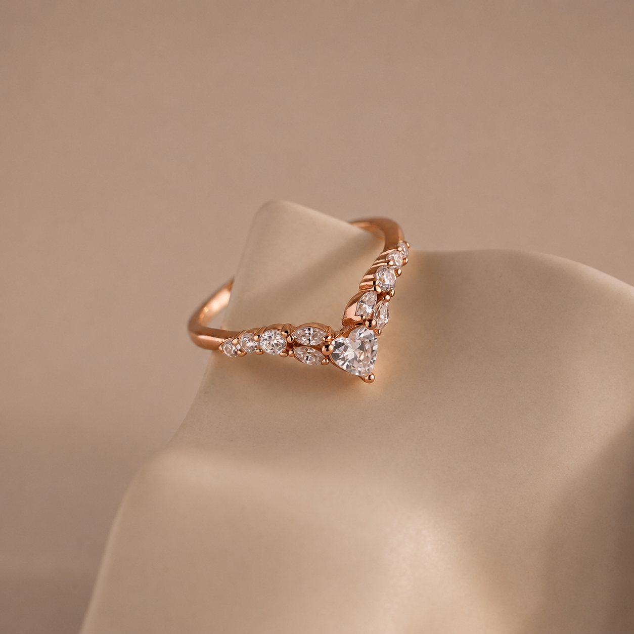 Rose gold ring with diamond accents on a beige background